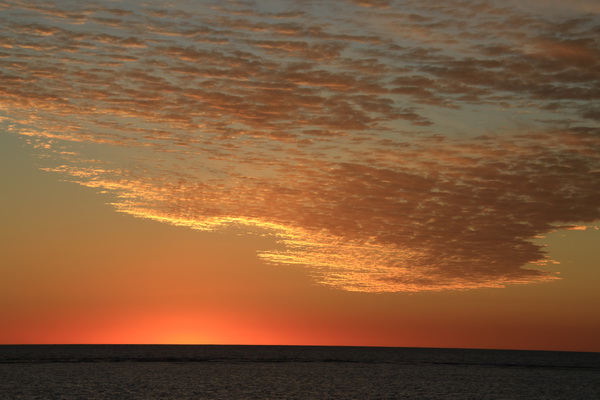 Zonsondergang met kleur op de wolken